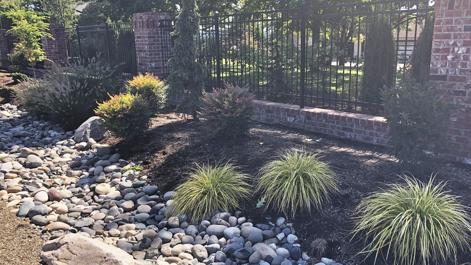 Landscaping installation with large rock border at a property in Washougal, WA.